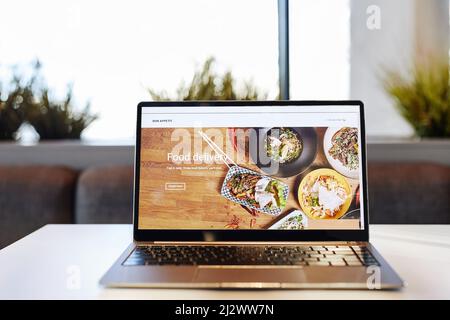 Background image of opened laptop with Food delivery website on table in cafe, copy space Stock Photo
