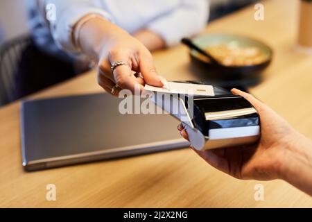 Close up of unrecognizable woman paying with credit card in cafe and using bank payment machine, copy space Stock Photo