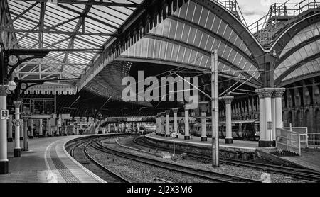 York Railway station where two19th Century canopies of iron and glass cover the platforms.  The platforms curve into the station. Stock Photo