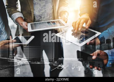 Ill share the information with you.... Cropped shot of unrecognizable businesspeople using their wireless devices in the office. Stock Photo