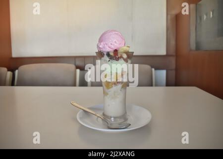 A Selectivefocus Picture of a colorful Ice cream with different flavors in a Glass container kept on a Table in restaurant. Are sold a lot in Summer Stock Photo