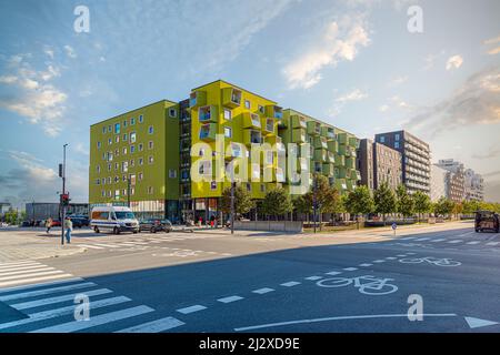 A modern residential building Ørestad plejecenter in bright light green color with windows and balconies in the form of cubes. Copenhagen, Denmark Stock Photo