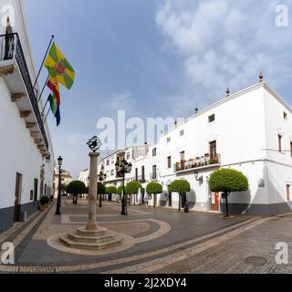 Olivenza, Spain - 27 March, 2022: orange trees and whitewashed buildings under a blue sky on the Plaza de la Constitucion Square Stock Photo