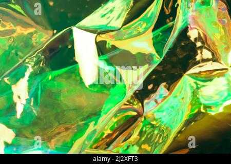 Blurred holographic background. Fluid multicolored texture of wrinkled foil in green colors. Stock Photo