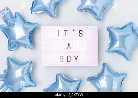 Its a boy - quote. Frame made of blue star foil balloons and lightbox. Stock Photo