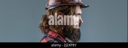 Builder in hard hat, foreman or repairman in the helmet. Building, industry, technology - builder concept. Bearded man worker with beard in building Stock Photo