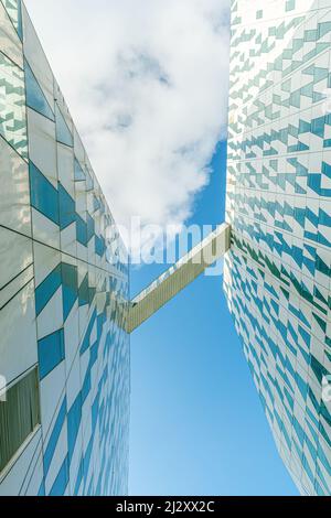 Transition block between two buildings of modern Bella Sky Comwell Hotel against the blue sky with clouds in Ørestad, Copenhagen, Denmark Stock Photo