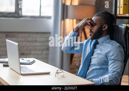 Exhausted company employee suffering from the eyestrain Stock Photo