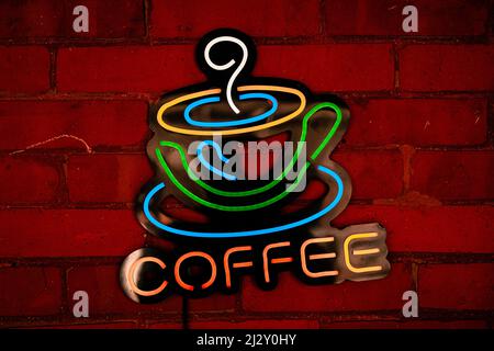 Neon coffee sign on brick wall Stock Photo