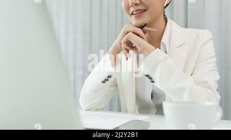 Confidence woman concept, Businesswoman wear bluetooth headphone to meeting on video conference. Stock Photo