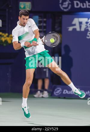 Serbian tennis player Novak Djokovic playing backhand return  shot at the Dubai Tennis Championships 2022, Dubai, United Arab Emirates Stock Photo