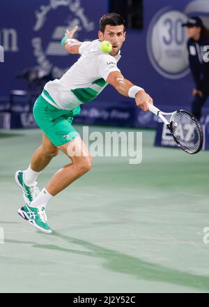 Serbian tennis player Novak Djokovic playing backhand return  shot at the Dubai Tennis Championships 2022, Dubai, United Arab Emirates Stock Photo