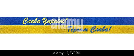 Stand with Ukraine: message Glory to Ukraine, Glory to Heroes in Ukrainian on felt ribbon with Ukrainian flag Stock Photo