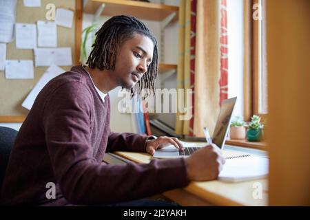 Male University Or College Student Studying With Laptop At Desk In Room Stock Photo