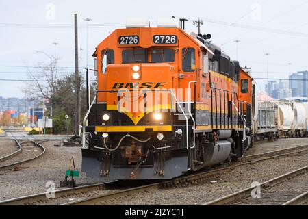 Seattle - April 03,  2022;  BNSF GP39-2 locomotive moving freight in downtown Seattle with bright headlights Stock Photo