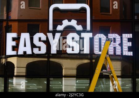 Putting up a lighted sign for an Easy Store as was about to open on Dale Street in Liverpool Stock Photo