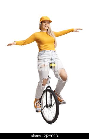 Young female riding a unicycle and smiling isolated on white background Stock Photo