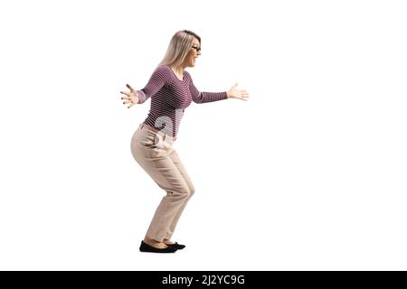 Full length profile shot of a happy young woman waiting with arms wide open isolated on white background Stock Photo