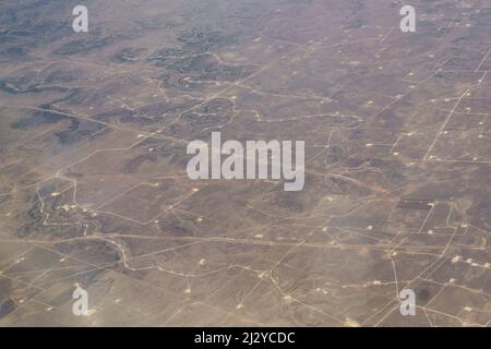 Aerial view of Field of West Texas Gas and Oil Fracking Pads and Wind Turbines, Resource Extraction Texas. Stock Photo