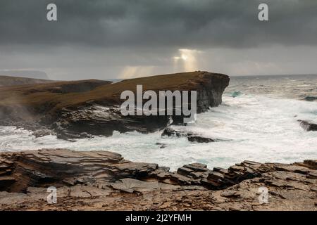 Storm, surf breaker, Yesnaby cliff, sunbeam through clouds, cliffs, Orkney, Scotland UK Stock Photo