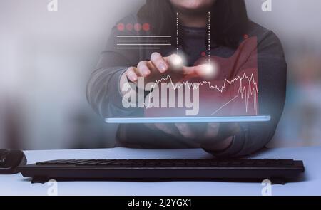 Business woman showing a growing virtual hologram stock on digital tablet. Stock market. Growth, progress and success concept. Stock Photo