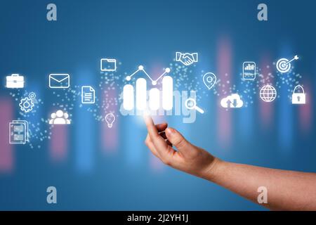 Hand pointing a growing virtual hologram stock with business icons. Stock market. Growth, progress, success, cloud, mail, contacts, global security. I Stock Photo