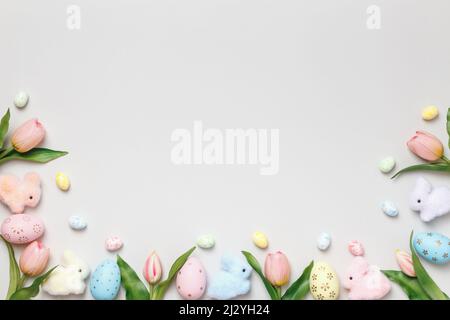 Easter composition. Tulips eggs toy rabbits on a gray background. Stock Photo