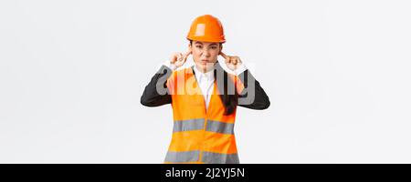 Engineer Shut Up Bothered and displeased asian female chief engineer shut ears and ...