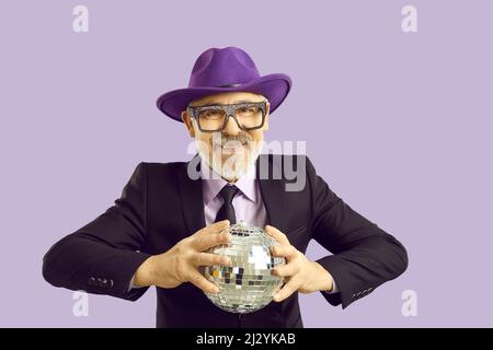 Mature man in hat and glasses with disco ball Stock Photo