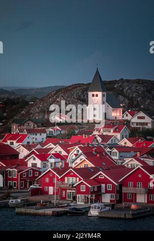 Red houses with a church in the village of Skärhamn on the archipelago island of Tjörn on the west coast of Sweden, in the evening Stock Photo