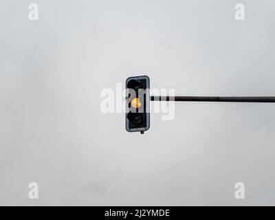 Yellow traffic light signal in front of an overcast sky. Light symbol to control the cars on the street and to guide the road user. Caution sign Stock Photo
