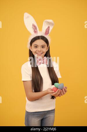 happy easter holiday. funny child in rabbit ears. smiling teenager girl in bow tie. bunny egg hunt. Stock Photo