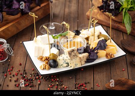 Assorted cheese appetizer platter with honey Stock Photo