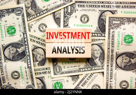 Investment analysis symbol. Wooden blocks with concept words Investment analysis on beautiful background from dollar bills. Business investment analys Stock Photo