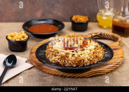 Transparent Plastic container with oriental honey sweets & cake with milk on a wooden table & black background, Black Plastic plate Stock Photo