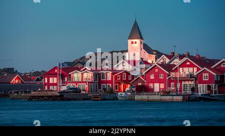 Red houses with a church in the village of Skärhamn on the archipelago island of Tjörn on the west coast of Sweden, in the evening Stock Photo