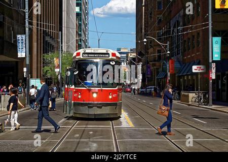 TORONTO, CANADA - 06 27 2016: City dwellers crossing the street in front of an old streetcar on King at Younge st. intersection Stock Photo