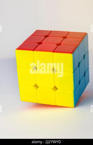 Rubik's cube on a white background. Problems on logic, Cube of yellow red and blue. Stock Photo