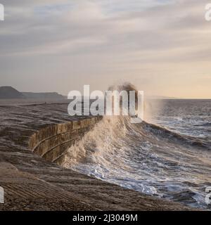 Waves created by Storm Barra crashing against The Cobb at Lyme Regis in Dorset, England, UK, just after sunrise the day after the main storm Stock Photo