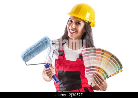 Cheerful young woman in workwear holding color palette and paintbrush - isolated white background. Stock Photo