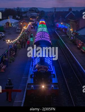 Locomotive 7828 Odney Manor pulling the illuminated 'Winter Lights' Christmas special passenger train on the West Somerset Railway at Bishops Lydeard. Stock Photo