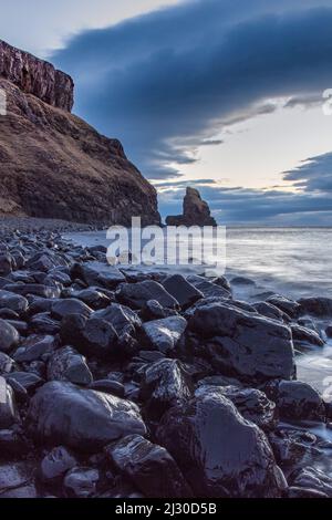 Dusk, shiny stones at low tide on Talisker Bay beach, Isle of Skye, Scotland, UK Stock Photo