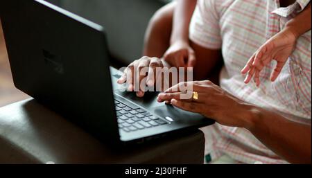 Black father working from home with child, african parent using laptop with son Stock Photo