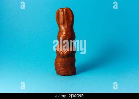 Easter Chocolate Bunny on Blue Background Creative Easter Holiday Concept Stock Photo