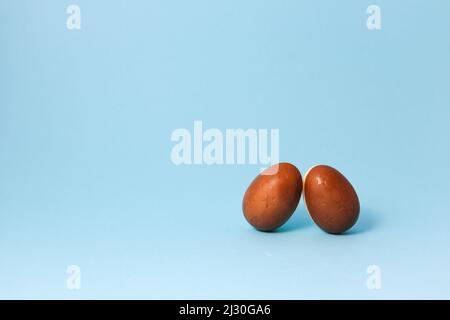 Two Chocolate Easter eggs on blue background. Close up Easter Concept Stock Photo