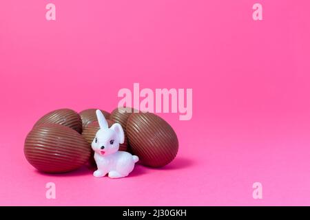 White rabbit watching over bunch of chocolate eggs Easter Holiday Concept Stock Photo