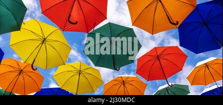 colorful umbrellas hanging against blue sky background. banner Stock Photo