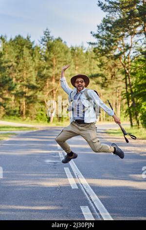 Young man jumping on rural road enjoying summertime freedom Stock Photo