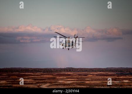 U.S. Army Cpt. Dylan J. Benit and Chief Warrant Officer 3 Robert Baxley, Apache helicopter pilots, assigned to the 1-3rd Attack Battalion, 12th Combat Aviation Brigade fly by to engage a target during helicopter gunnery training at Camp Adazi, Latvia, March 31, 2022. 12 CAB is among other units assigned to V Corps, America's Forward Deployed Corps in Europe that works alongside NATO Allies and regional security partners to provide combat-ready forces, execute joint and multinational training exercises, and retains command and control for all rotational and assigned units in the European Theate Stock Photo