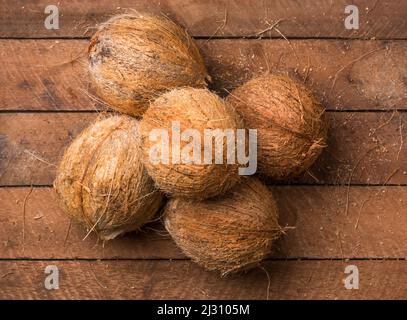 coconut, healthy tropical fruits without husk on a wooden table top, taken from Stock Photo